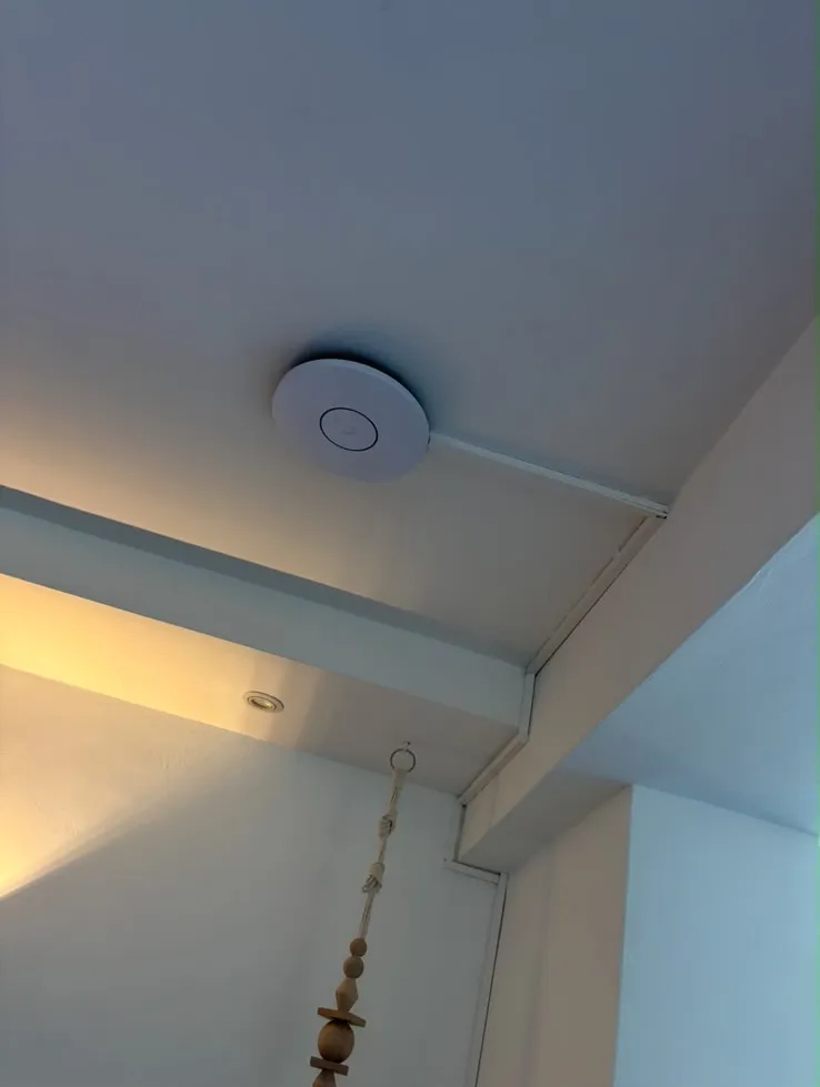 UniFi Access Point an der Wohnzimmerdecke, per LAN angebunden
